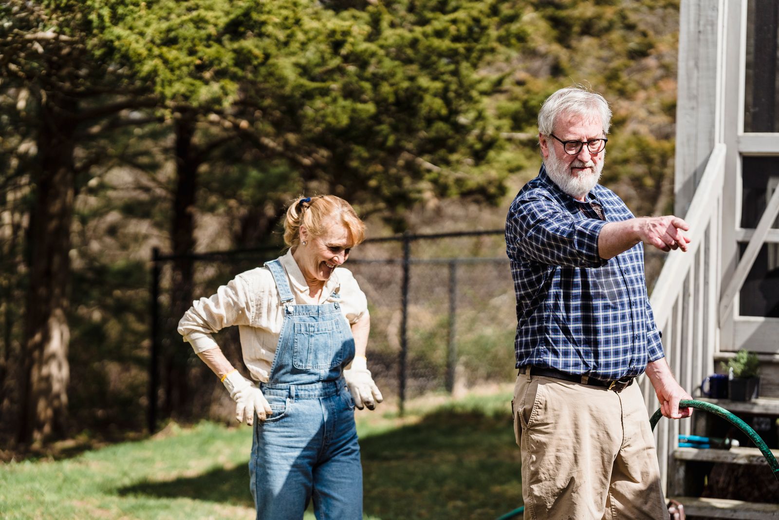 An older couple laughing together outdoors on a bright day