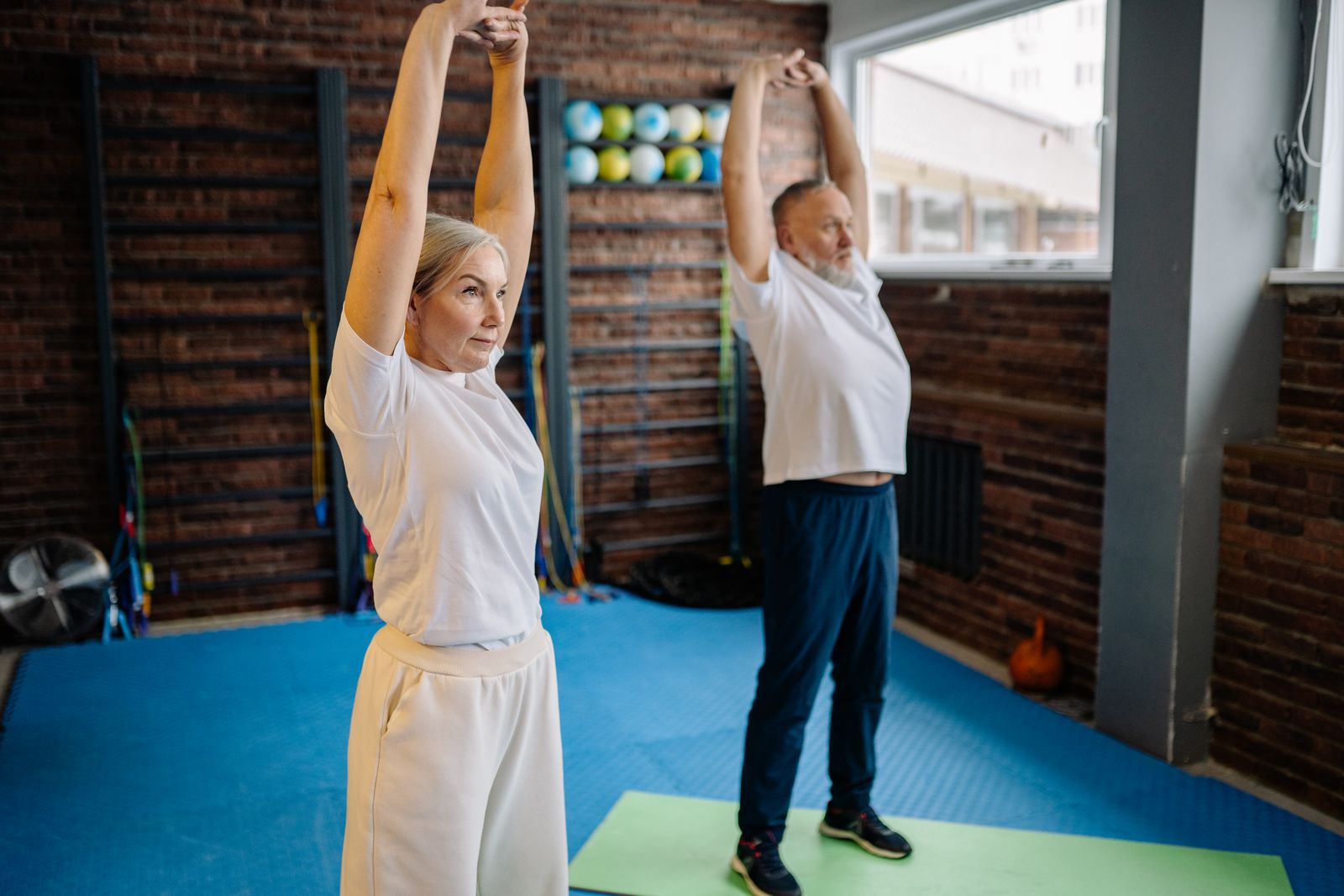 An older couple doing a guided stretching and strength session